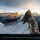 Monat: Dezember 2023. Schneebedeckte Berge, ruhiger See, dramatisches Licht. Unten Kalenderaufdruck.