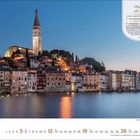 "Yinanstieg des Elans", Text über die Bedeutung von Yin. Szene: Küstenstadt bei Dämmerung, beleuchtete Altstadt mit Turm.