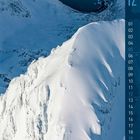 Ein Kalender mit der Zahl 12 und den Tagen 1 bis 31. Schneebedeckte Berglandschaft unter blauem Himmel.
