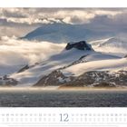 Sonnenaufgang auf der Antarktischen Halbinsel nahe der Trinity-Insel. Schneebedeckte Berge über einem ruhigen Meer.