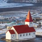Kalenderansicht mit der Zahl "12" in Weiß und Tagen des Monats. Eine Kirche vor einer Winterlandschaft mit Bergen.