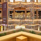 Zitat von Walt Disney über Bücher. Große Bibliothek mit hohen Regalen und schwebenden Planeten. Kalender zeigt Monat 12.