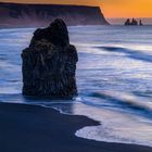 Perlmutterwolken über dem schwarzen Strand Reynisfjara bei Vík. Unten ein Kalender für Dezember mit Datum und Wochentagen.