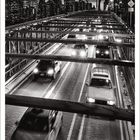 Text: "Brooklyn Bridge mit Skyline von Downtown". Schwarz-Weiß-Foto einer belebten Brücke bei Dämmerung.