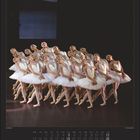 Kalenderseite für Dezember. Acht Tänzerinnen in weißen Tutus stehen eng beieinander auf einer Bühne.