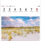 Kalenderwoche vom 2. bis 8. August. Foto zeigt eine Dünenlandschaft mit Gras unter blauem Himmel mit Wolken.