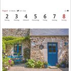 August, 31. Woche, 2.-8.8., Montag-Sonntag. Traditionelles Steinhaus in Saint-Suliac mit blauer Tür und Gartenmöbeln.