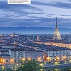 Blick auf Turin, Mole Antonelliana, Nationales Filmmuseum, Bergkulisse, beleuchtete Stadtansicht, Fluss im Vordergrund.