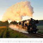 Dezember-Kalender mit Dampflok auf Schienen, riesige Dampfwolke, Felder und Bäume im Hintergrund.