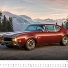 „Dezember“, „1969er Oldsmobile Cutlass F-85 W-31“, rotes Auto in bergiger Landschaft, Tannenbäume, Sonnenuntergang.