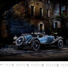 Dezember-Kalenderseite: Ein eleganter, blau-grauer Oldtimer steht vor einer rustikalen alten Steinmauer.