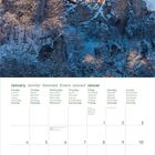 Kalenderseite für Januar in mehreren Sprachen. Oben ein schneebedecktes Schloss auf einem Felsen unter blauem Himmel.