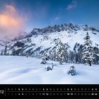 Kalenderblatt mit Dezemberdaten, Bild von schneebedeckten Alpen, rosa Wolken und Tannen im Vordergrund.