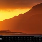 Schottland 12. Sonnenuntergang am Loch Maree in den westlichen Highlands. Silhouette von Bergen vor orange-gelbem Himmel.