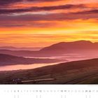 "Sonnenaufgang im Westen der Halbinsel Iveragh, County Kerry." Kalendarium mit Nummern. Landschaft mit Hügeln und See.