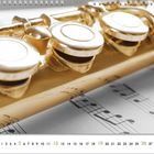 Kalender unten: 12. Oben Notenblatt und goldene Querflöte, Nahaufnahme der Klappen.