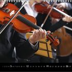 Kalender; Dezember; Zahlen 1 bis 31; Violinspieler in Anzug, Hintergrund unscharf, Musikinstrumente und Notenständer.