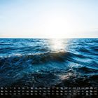 Kalender mit Zahlen 1-31, Wochentage darunter. Darauf blaues Meer und Sonnenlicht am Horizont.