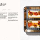 Text: "Tamago sando mit Seeigel und Ikura." Zwei belegte Sandwiches auf einem Tablett, mit Kräutern garniert.