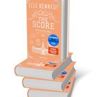 Covertext: "Elle Kennedy, THE SCORE, MITTEN INS HERZ, ROMAN." Sticker: "OFF CAMPUS Now an Original Series prime." Illustration von Hockey-Elementen und einem Gebäude.