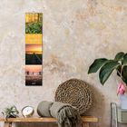 "Bezaubernde Augenblicke 2021" auf einem Wandkalender mit Naturmotiven, daneben Pflanze, Uhr und Deko.