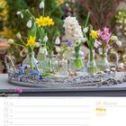 Traubenhyazinthe, Zwergiris, Schneeglöckchen ... März 2027. Gelbe, weiße, blaue und rosa Blumen in Vasen auf einem Tablett.