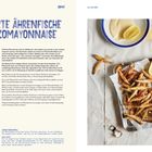 Große blaue Schrift: "FRITTIERTE ÄHRENFISCHE MIT OUZOMAYONNAISE". Foto: Frittierte kleine Fische mit Zitronenhälfte.