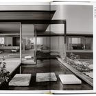 Text: "View north through the living area to the original library/den for a completely transparent view through the house."

Moderner Wohnraum mit großen Glasflächen, Seerosen auf Wasser.