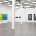 Kunstgalerie mit modernen, abstrakten Gemälden: bunte Streifen links, geometrische Schwarz-Weiß-Muster rechts.