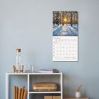 Kalender zeigt Januar 2027. Foto: Winterwald im Schnee mit Sonnenuntergang. Darunter: weiße Regal mit Krug, Gläser und Bücher.