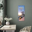 „Magische Momente am Meer 2024“ steht auf einem Kalender an einer grünen Wand. Daneben: Tisch, weiße Vase mit Blumen.