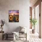 „Magische Augenblicke der Natur. 2023.“ Ein Kalender mit Sonnenblumenmotiv an einer hellen Wand, daneben eine Holzbank.