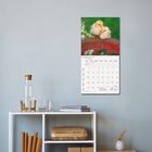 MÄRZ 2022 steht oben auf einem Kalenderblatt. Darüber sind zwei gelbe Küken auf einem Ast. Darunter ein Regal mit Flasche und Büchern.