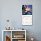 Text "August 2023". Ein Kalender hängt an der Wand. Darunter ein Regal mit Dekorationen.