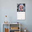 Der Text "MÄRZ 2027" steht auf einem Kalender. Darüber sieht man Eis am Stiel auf Eiswürfeln. Darunter ist ein Regal.