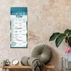 Kalenderaufschrift: "2027 TIMER FOR 2 COLOUR Flow". Befestigt an einer Wand, daneben Kissen und Pflanzen.