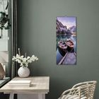 Text: "Südtirol". Zwei Boote auf einem ruhigen See, umgeben von Bergen. An einer grünen Wand hängt ein Poster in einem Raum.