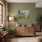 „Tierwelt Wald“ steht auf einem Kalender mit Hirschbild. Warmes Wohnzimmer mit Holzkommode, Pflanzen, Lampen und Bücher.