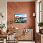 Text: "Italien 2027." Ein Kalender hängt an einer Terrakottawand. Darunter stehen Holzmöbel mit Geschirr und Pflanzen.