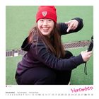 „November“ in Pink. Datenkalender unten, „Juliana“ links. Frau mit roter Mütze und Kamera, lächelnd, kniend auf grünem Boden.
