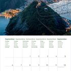 Kalenderseite September mit Wochentagen in mehreren Sprachen. Oben eine Stadtansicht bei Sonnenuntergang mit Bergen und Meer.