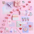 Texte: "I LOVE YOU", "BEST FRIENDS". Pastellfarbene Briefumschläge, Sticker und Dekorationen auf rosa Hintergrund.