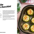 "Gefüllte runde Zucchini"; Rezept mit Zutaten wie Ricotta, Parmesan, und Zucchini; Bild zeigt Zucchini in einer Backform.