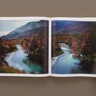 Unten klein steht "Valley, River" und "Step in the Flow, 2019". Zu sehen ist ein offenes Buch mit Fotos einer Flusslandschaft.