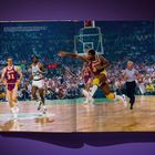 Basketballspiel mit drei Spielern und einem Schiedsrichter. Zwei Spieler in Lakers-Trikots, einer in Celtics-Trikot. Actionreich.