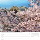 Blühende Kirschbäume vor gewölbter Brücke. Kalender mit Daten von 15. bis 21. März, 11. Woche, März markiert.