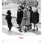 Pudel Skippy führt Kinder über Zebrastreifen in Heston, Großbritannien, 1954. Kalender für März 2027.