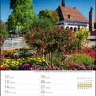 Freudenstadt – der Marktplatz mit seinen 50 Wasserfontänen. Kalender für Juli 2027. Blumenbeet, Brunnen, Fachwerkhaus.