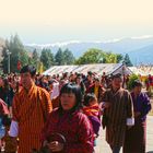 „LAND UND LEUTE“ steht oben. Eine Gruppe von Menschen in bunter traditioneller Kleidung vor einer Berglandschaft.