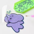 Eine lila Elefantenfigur mit Perlen mustern und ein grünes Fach mit lila Perlen, daneben ein pinker Stift.